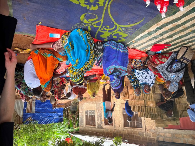 En gruppe mennesker i Zanzibar som sitter på bakken