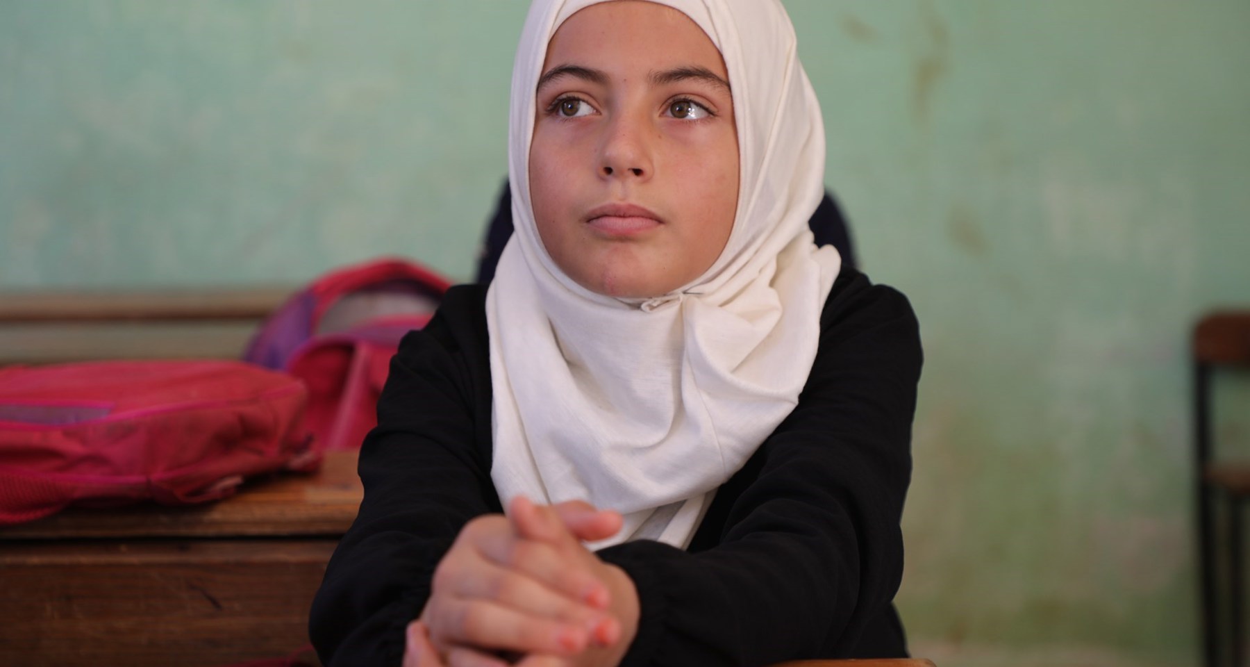 Ung jente i hijab ser lengtende bort.